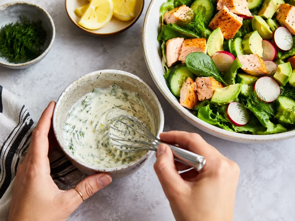 Cremiges Dill-Dressing wird für den Lachs-Avocado-Salat angerührt